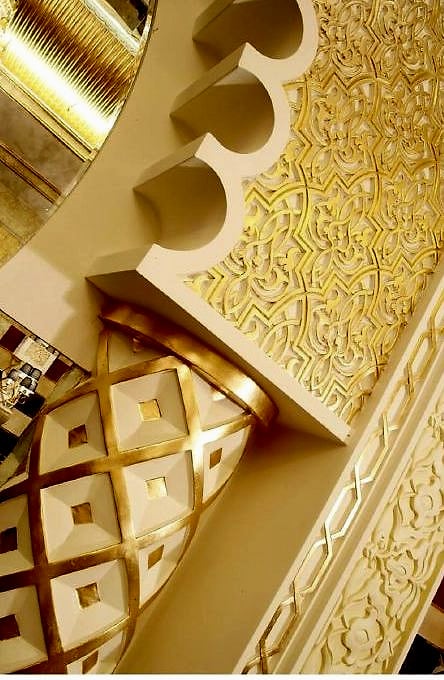 ورقُ ذهبٍ مفروشٌ فوق زخرفةٍ منحوتة — تفصيلٌ عن قرب